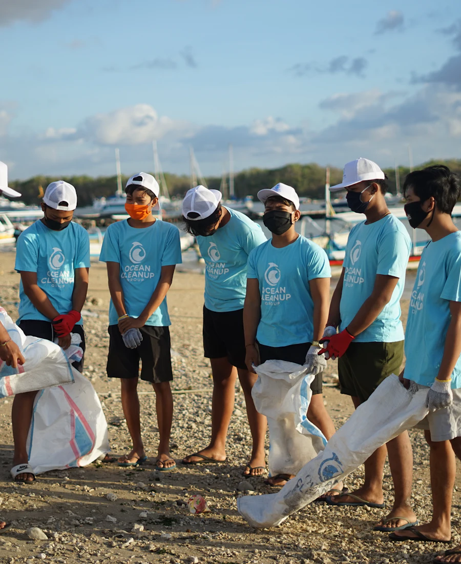 Team in matching shirts collecting litter along a waterfront