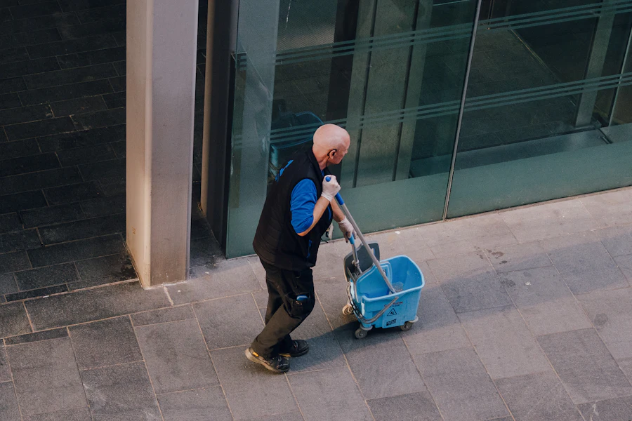 Cleaner pushing a service cart outside a commercial building