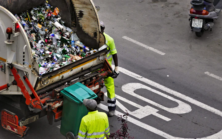 Collection crew loading household waste into a refuse truck